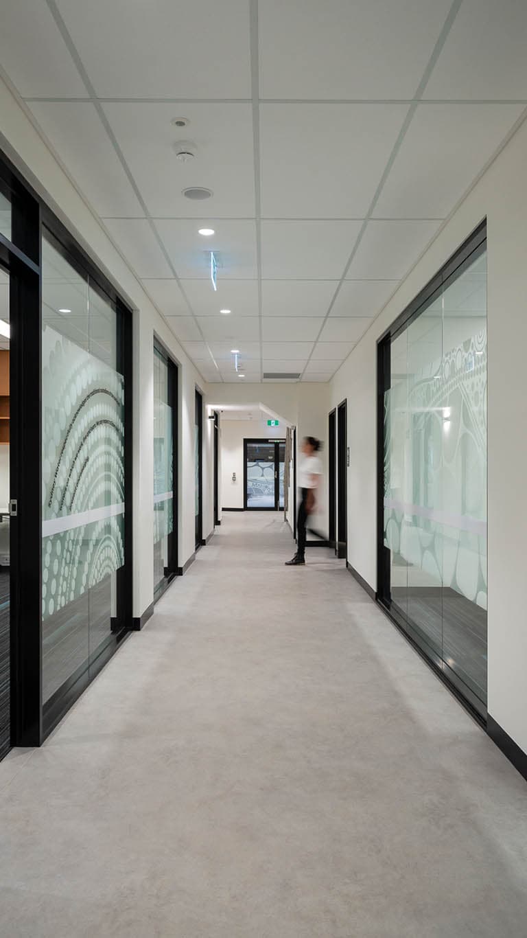 Office corridor, glazed meeting rooms with Aboriginal-inspired artwork film