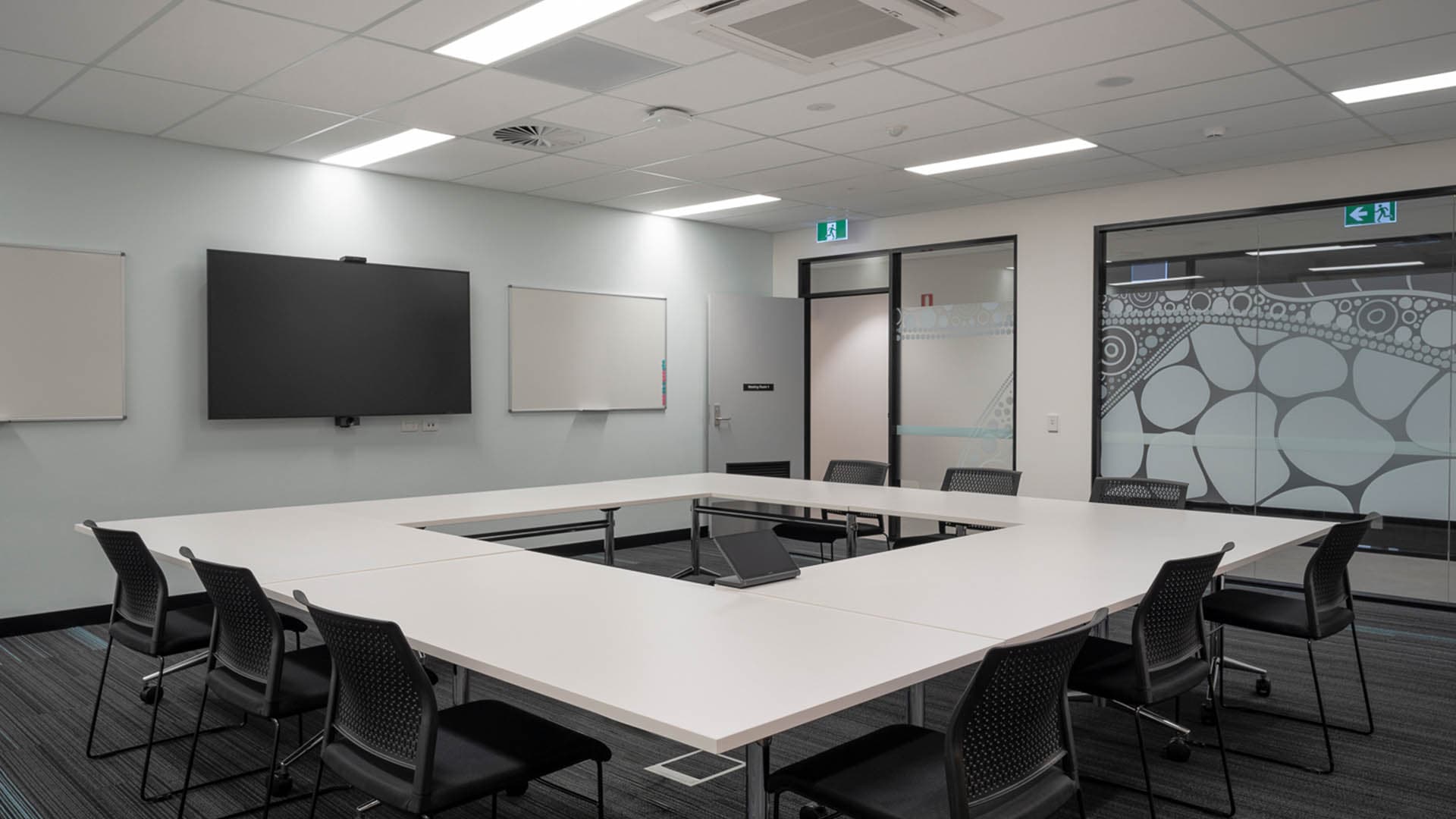 Meeting room with AV, whiteboard and Aboriginal artwork glazing film